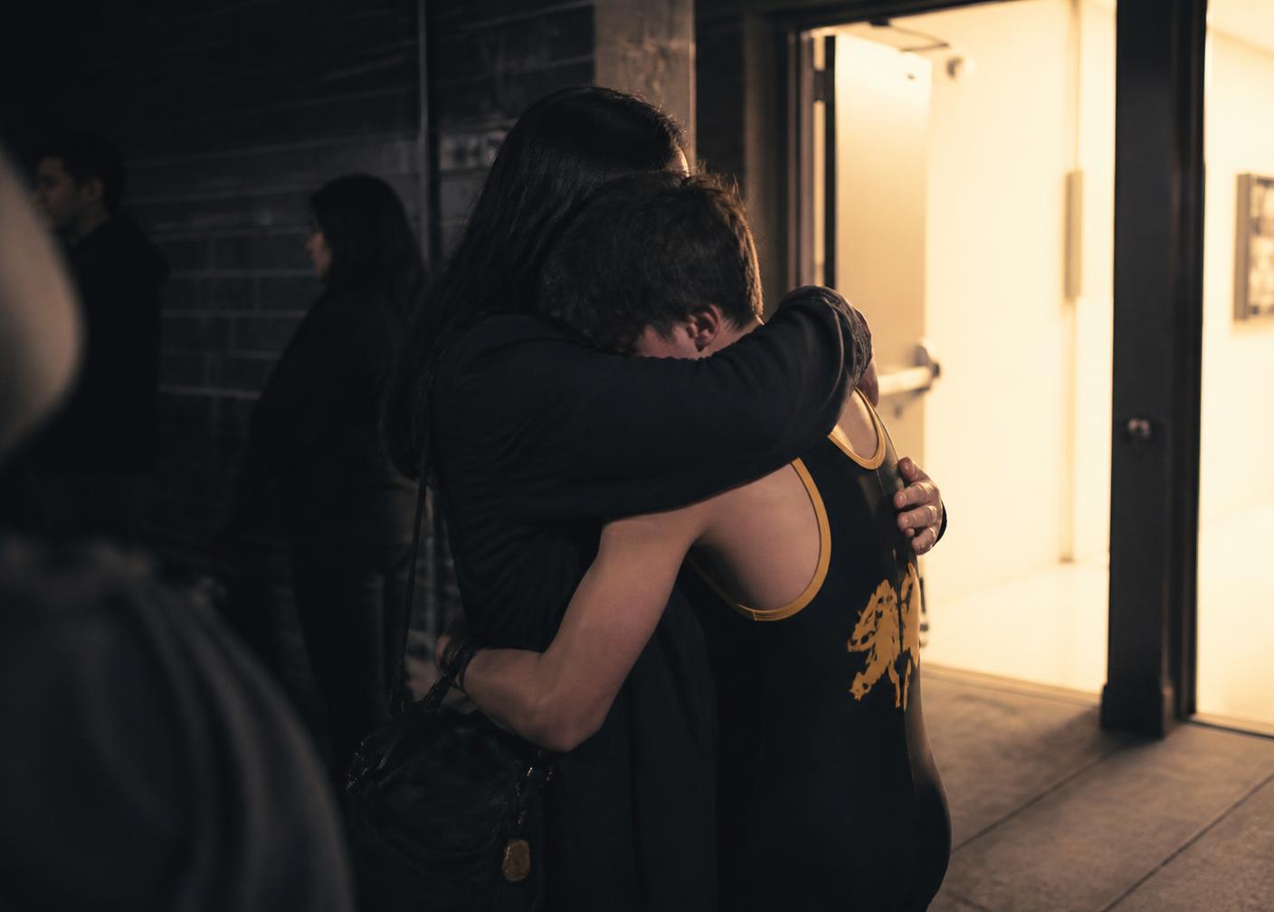 A parent embracing their young athlete after a game